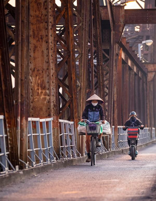 A rural woman crosses the bridge at dawn to enter the Old Quater to sell vegetables. A rural woman crosses the bridge at dawn to enter the Old Quater to sell vegetables.