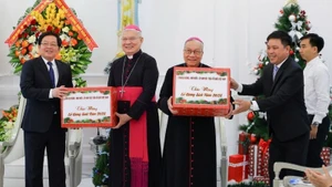 On behalf of the Party and the State, Deputy Prime Minister Ho Quoc Dung presents Christmas gifts to the Archbishop of the Archdiocese in Hue.