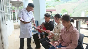 Health workers at Tan Xuan Health Station, Xuan Nha Commune, Son La Province, deliver leaflets on reducing the sex ratio imbalance at birth.