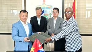 Luis Alberto Hernandez Tejeda, General Director of Alquizar Agricultural Company, and Nguyen Khac Hoang, General Director of Hoang Gia Viet Food Joint Stock Company, exchanged the cooperation document. (Photo: Embassy of Viet Nam in Cuba)