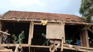 Officers and soldiers from My Ly Border Guard Station, Nghe An Province, help local people clean and repair their houses after floods. (Photo: Viet Lam)