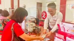 Customers conduct transactions at an Agribank branch. (Photo: HONG ANH/NDO)