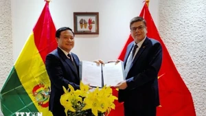 Ambassador Bui Van Nghi (L) presents the decision of Deputy Prime Minister and Minister of Foreign Affairs Bui Thanh Son on reappointing Miguel Angel Pérez Peña as Honorary Consul of Vietnam in Bolivia. (Photo: VNA)