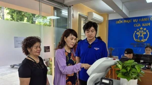 Residents use an AI robot to assist with administrative procedures in Cua Nam Ward, Ha Noi. (Photo: NDO)