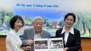 A representative of the family of Trinh Hai presents photos to the President Ho Chi Minh Relic Site on March 12. (Photo: VNA)