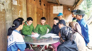 Police officers in Tra Tap Commune, Da Nang City, check the voter list while organising communication activities on election day. (Photo: NDO)