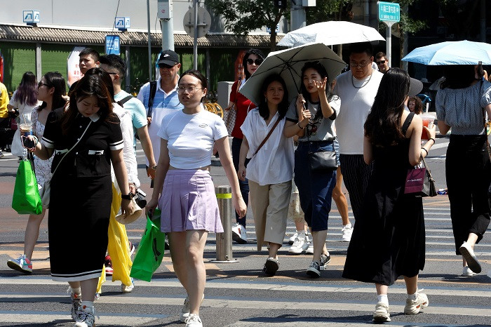 People walk on a street amid an orange alert for heatwave in Beijing, China June 22, 2023. (Photo: Reuters)
