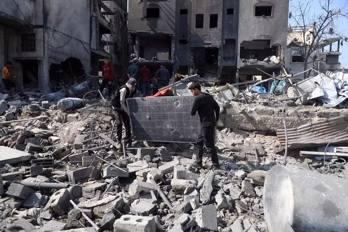 People clear debris from buildings damaged by Israeli airstrikes in the Shuja'iyya neighborhood, east of Gaza City, on March 18, 2025. The Palestinian death toll from Israeli airstrikes across the enclave early Tuesday has risen to 413, Gaza health authorities reported, adding women and children were among those killed. (Photo: Xinhua)