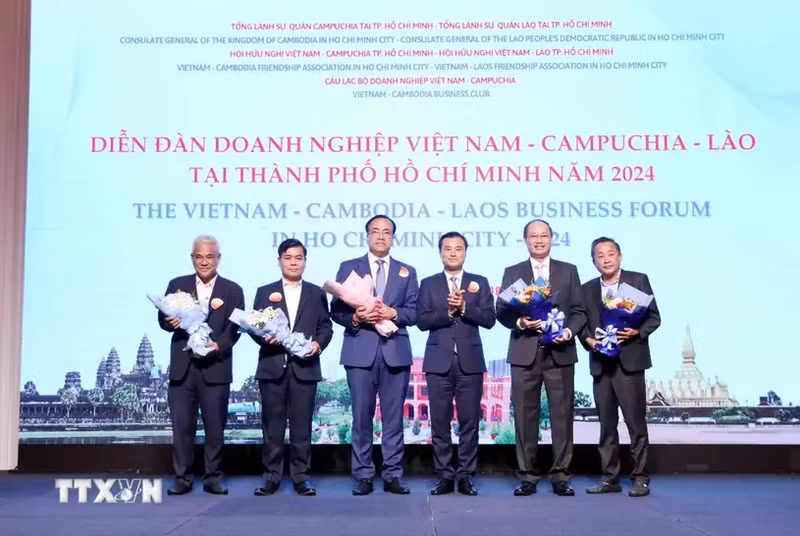 Vice Chairman of the Ho Chi Minh City People's Committee Bui Xuan Cuong (3rd from right) gives flowers to representatives of the forum organising board. (Photo: VNA)