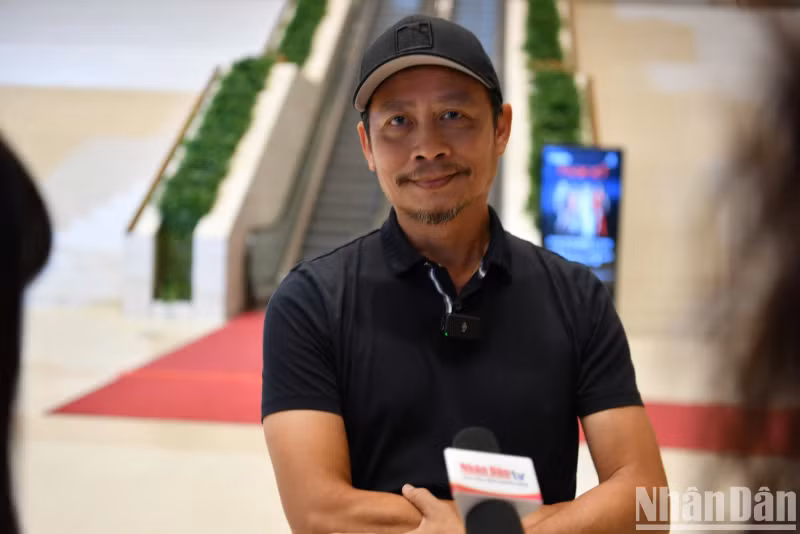 Director Pham Hoang Nam talks to the press after the show.