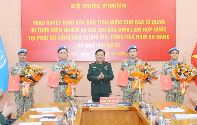 Deputy Minister of National Defence Sen. Lieut. Gen Hoang Xuan Chien (middle) presents the President's decision to four military officers (Photo: VNA)