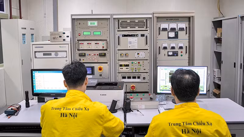 Staff at the Hanoi Irradiation Centre operate the cyclotron accelerator to produce the radiopharmaceutical FDG. (Photo by SON TUNG)