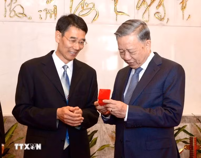 The head of the President Mao Zedong Memorial House presents a souvenir to General Secretary and President To Lam.