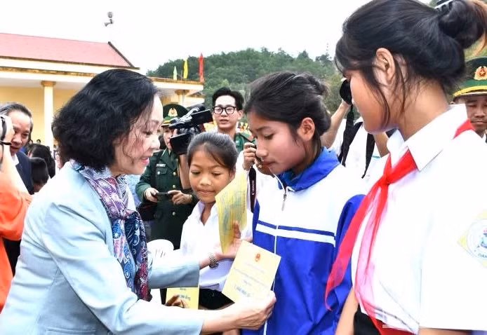 Politburo member Truong Thi Mai presents gifts to students in Dan Hoa Commune.