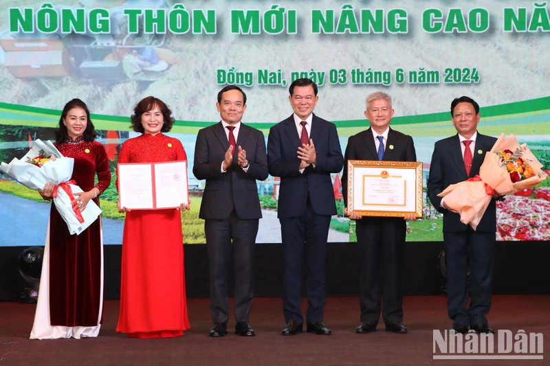 Deputy Prime Minister Tran Luu Quang presents the title to Xuan Loc District. (Photo: NDO)