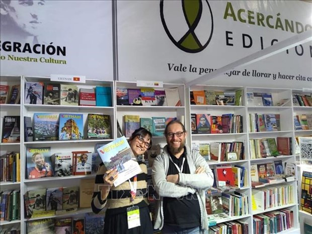 Readers with a publication of the Vietnam News Agency at the fair (Photo: VNA)