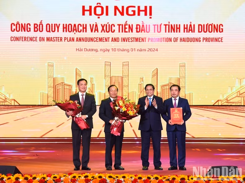 Prime Minister Pham Minh Chinh hands over the Decision announcing the Hai Duong Province's master plan to the leaders of Hai Duong Province.