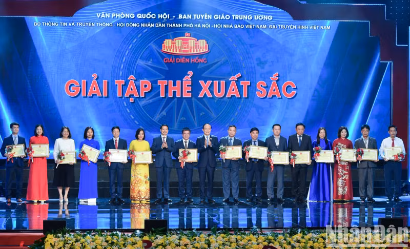 Nguyen Ngoc Tuan, Chairman of the Hanoi People's Council and Pham Thai Ha, Vice Chairman of the NA Office and the Assistant to the NA Chairman, present certificates of merit to 15 outstanding collectives for their contributions to the second Dien Hong Award.