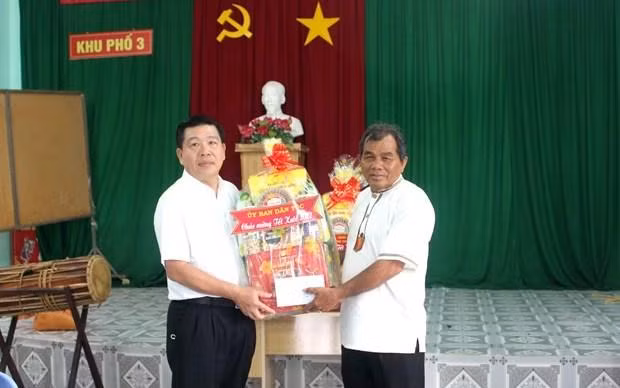 Deputy Minister-Vice Chairman of the Committee for Ethnic Affairs Le Son Hai (L) presents gifts to a dignitary in Binh Thuan. (Photo: VNA)