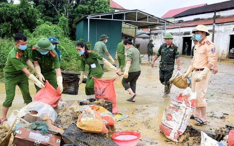 Police force and army soldiers clear a flooded street caused by heavy rains in Thanh My commune, Thanh Chuong district, Nghe An province (Photo: Xuan Hoang)