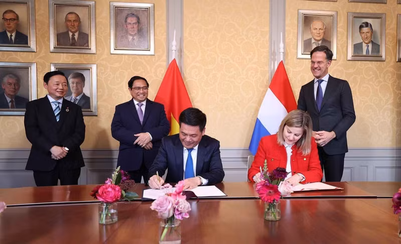 PM Pham Minh Chinh (behind, second from left) and his Dutch counterpart Mark Rutte (behind, first from right) witness the signing of a joint statement on emission reduction in manufacturing and consumption between the Vietnamese Ministry of Industry and Trade, and the Dutch Ministry of Foreign Affairs. (Photo: VNA)