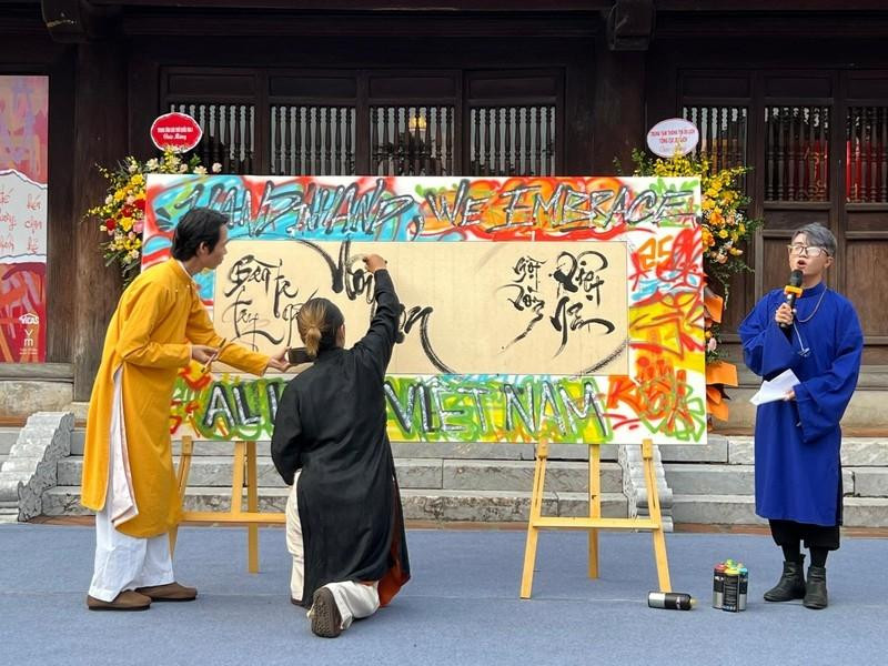 Two artists join hands to create an artwork at the exhibition (Photo: baodantoc.vn)
