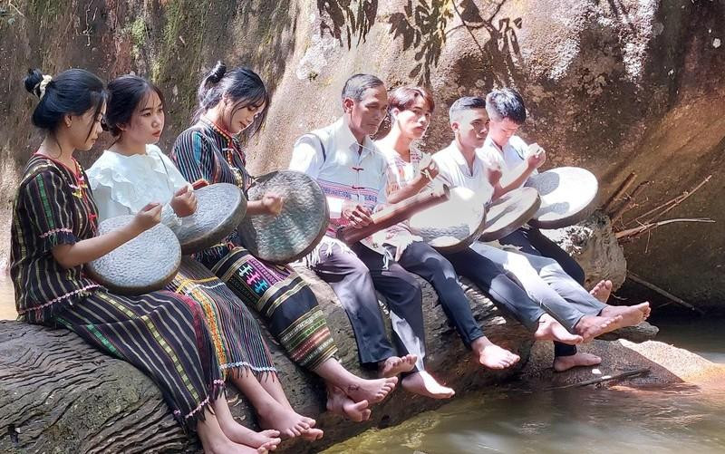 Elder K’Troi (centre) teaches students how to play a traditional musical instrument of the Ma ethnic people.