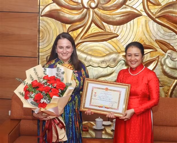 VUFO President Nguyen Phuong Nga presents insignia to UN Women Representative in Vietnam Elisa Fernandez (Photo: VNA)