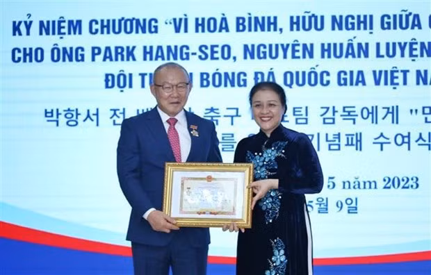 Ambassador Nguyen Phuong Nga (right) presents the insignia to coach Park Hang-seo. (Photo: VNA)