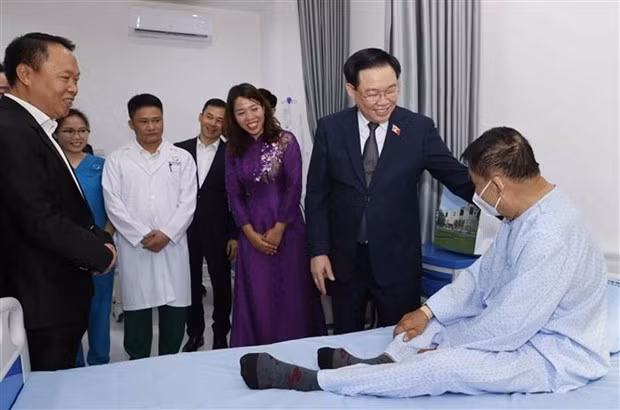 NA Chairman Vuong Dinh Hue visits a patient at the hospital. (Photo: VNA)