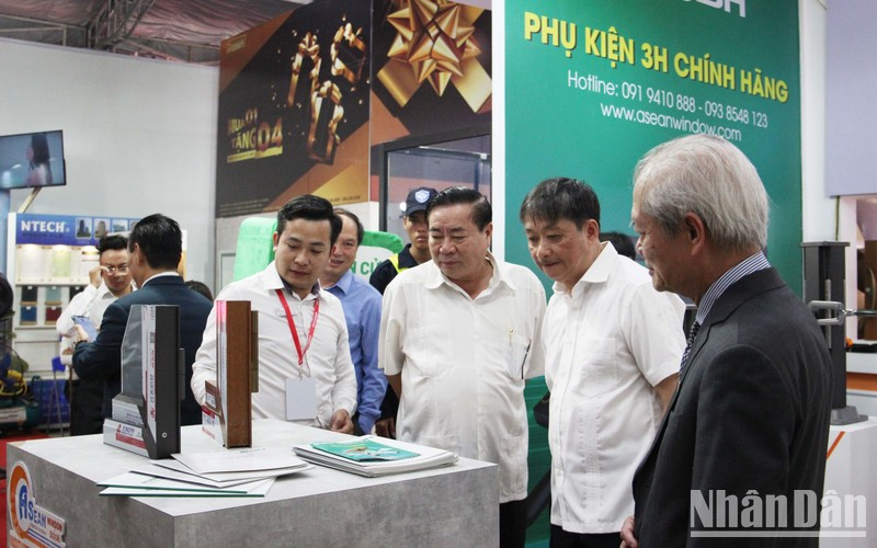Delegates visit a booth at the exhibition. (Photo: NDO)