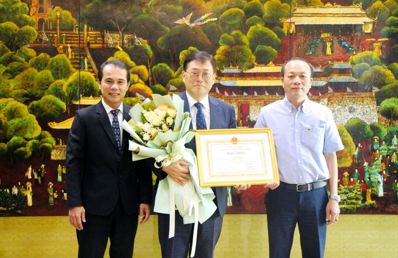 Leaders of the People's Committee of Thua Thien Hue province and Hue city present the certificate of merit and flowers to the KOICA Vietnam Director 