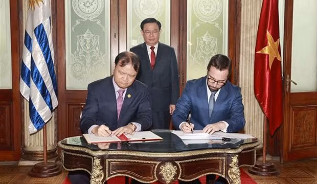 NA Chairman Vuong Dinh Hue witnesses the signing of the minutes of the third meeting of the Joint Committee for Economic, Trade and Investment Cooperation of Vietnam and Uruguay. (Photo: VNA)