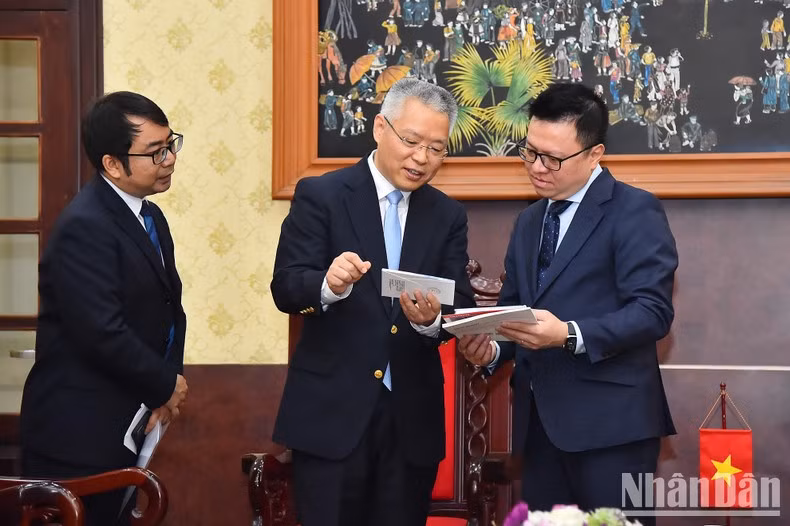 Le Quoc Minh and Hu Zhaoming exchange information after the meeting. Le Quoc Minh and Hu Zhaoming exchange information after the meeting.