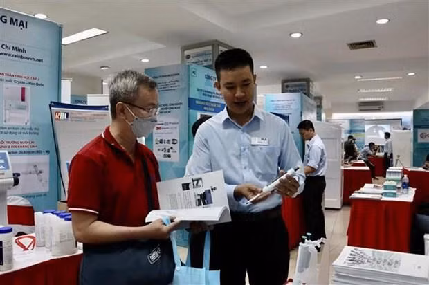 An exhibitor introduce new technology to a visitor at the fair. (Photo: VNA)