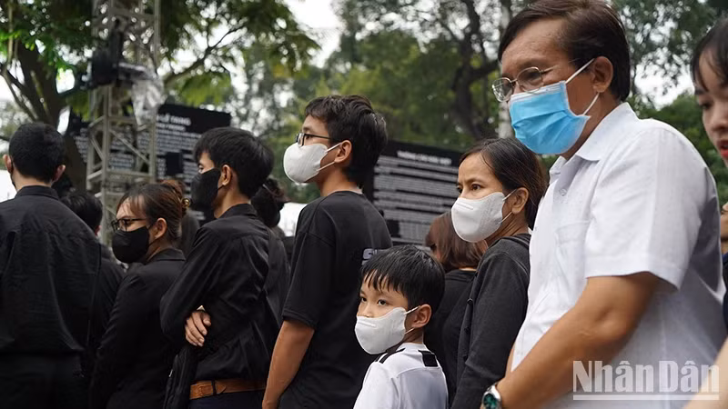 Children and their parents wait to enter the Reunification Hall to pay their respects to General Secretary Nguyen Phu Trong after work.