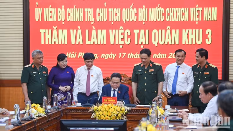 NA Chairman Tran Thanh Man writes in the traditional golden book of Military Region 3 Command.
