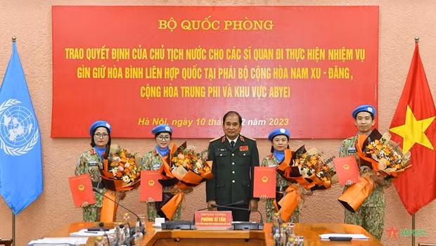 Deputy Chief of the General Staff of the Vietnam People's Army Sen. Lieut. Gen Phung Si Tan hands over the State President's decisions to four peace keepers. (Photo: qdnd.vn)
