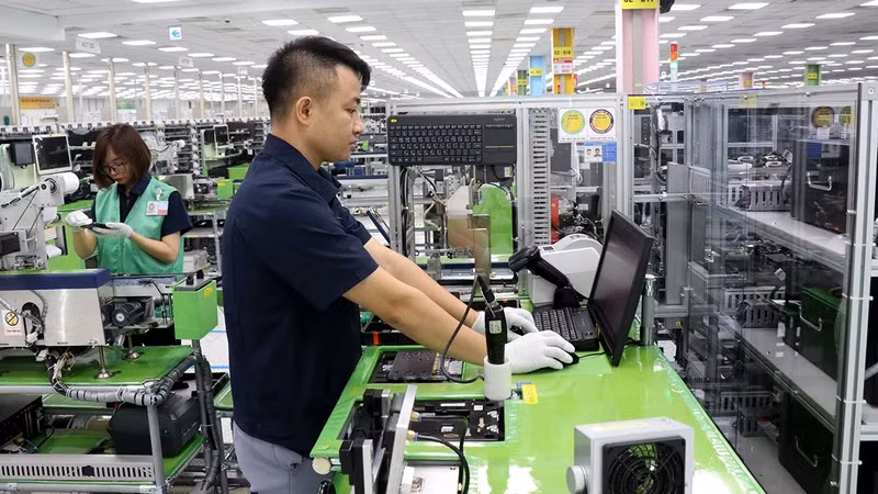 Workers of Samsung Electronics Vietnam Company operate the system of manufacturing and assembling electronic components.