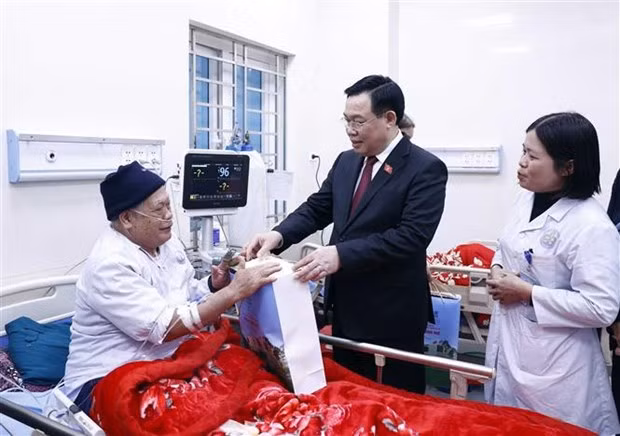 NA Chairman Vuong Dinh Hue visits a patient at Dinh Hoa general hospital (Photo: VNA) 