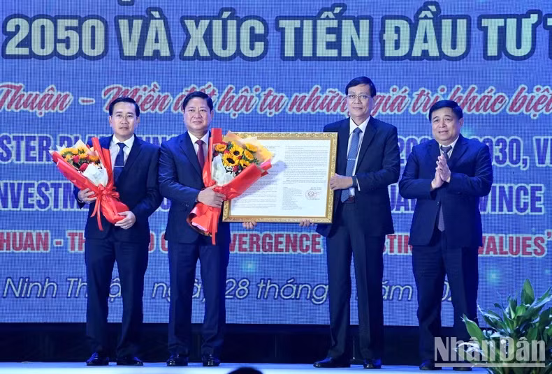 Minister of Planning and Investment (R) presents the decision approving Ninh Thuan's master plan to its leaders. (Photo: VNA)