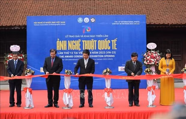 Participants cut a ribbon to launch the exhibition (Photo: VNA) 