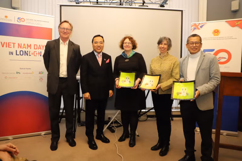 Vietnamese Ambassador to the UK Nguyen Hoang Long presents gifts to the three speakers at the event. (Photo: VNA)