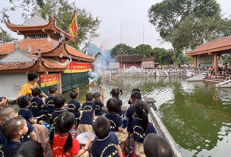 Students watch a water puppet show in Dao Thuc Water Puppet Ward, Thuy Lam Commune, Dong Anh District.