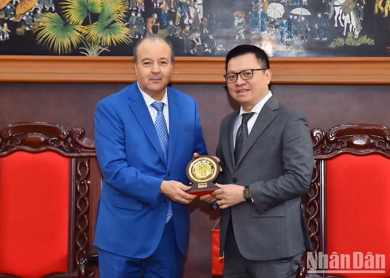 Editor-in-Chief Le Quoc Minh (R) presents Ambassador Abdelhamid Boubazine with the logo of Nhan Dan Newspaper. (Photo: NDO/Thuy Nguyen)