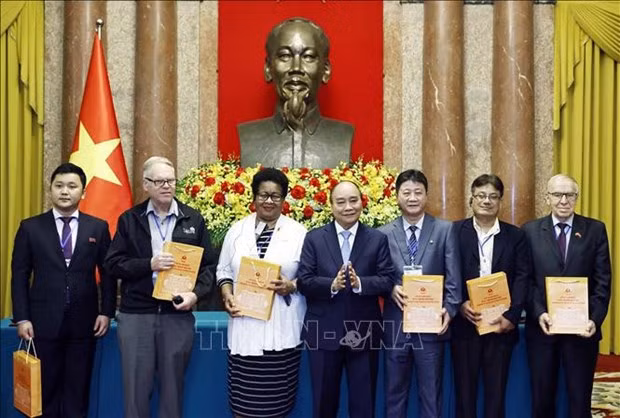 President Nguyen Xuan Phuc (C) presents gifts to delegates to the 22nd Assembly of the World Peace Council. (Photo: VNA)