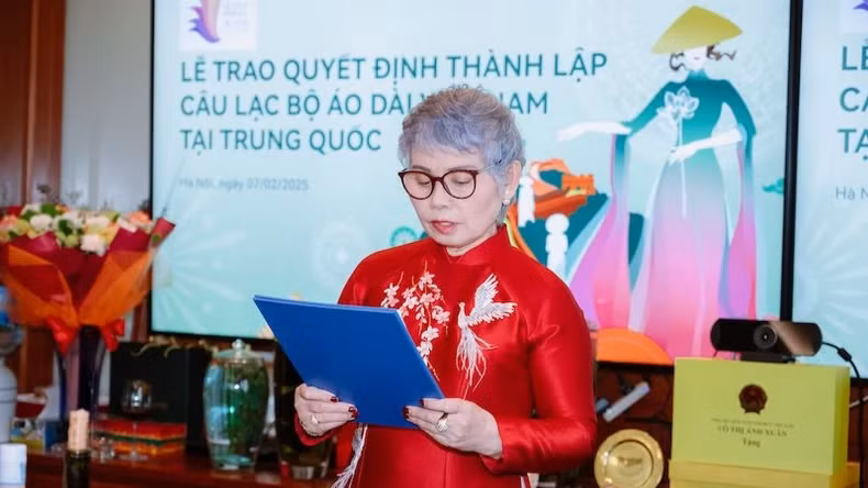 Khuc Thi Dau, Vice President of the Vietnam 'Ao dai' Heritage Club, reads the decision to establish the Vietnam 'Ao dai' Heritage Club in China.