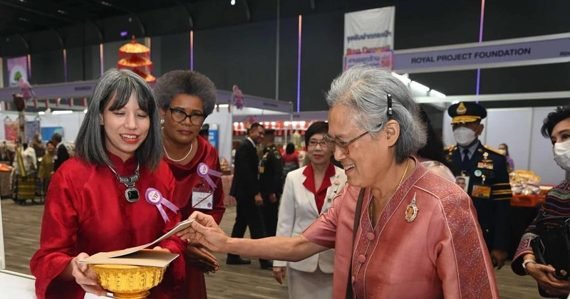 Ho Thi Thu Trang (left), spouse of the Vietnamese Ambassador to Thailand, invites Thai Princess Maha Chakri Sirindhorn to a lottery ticket of the bazaar. (Photo: VNA)
