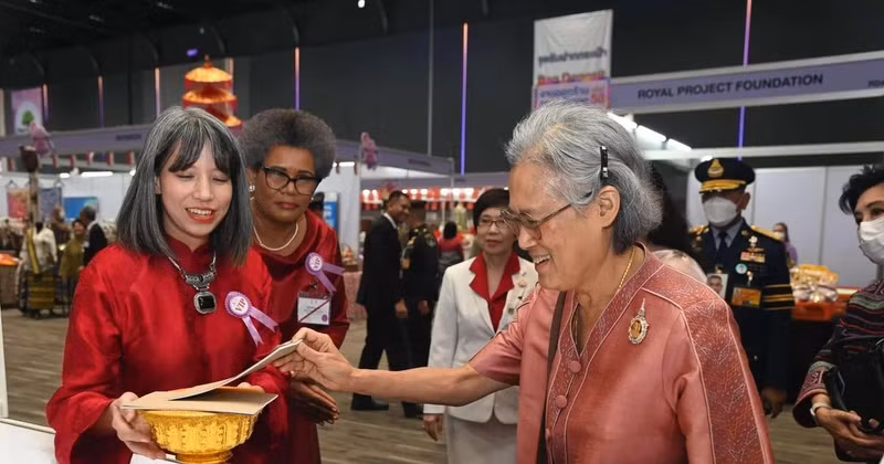 Ho Thi Thu Trang (left), spouse of the Vietnamese Ambassador to Thailand, invites Thai Princess Maha Chakri Sirindhorn to a lottery ticket of the bazaar. (Photo: VNA)
