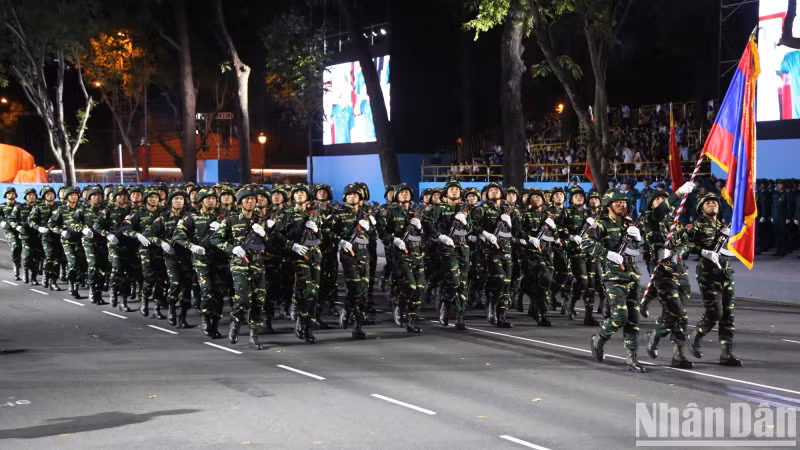 The Lao People's Army, in combat uniforms, march in formation, showcasing the deep solidarity and close ties between Vietnam and Laos in the journey of peacekeeping and development.